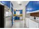 Retro kitchen featuring blue cabinets, stainless refrigerator, and laundry area nearby at 4401 Quieto Ct, Denver, CO 80211