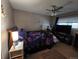 Bedroom featuring a ceiling fan, window with blinds, and a bed with a dark floral comforter at 604 S Xenon Ct, Lakewood, CO 80228