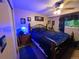 Cozy bedroom with a plush bed, ceiling fan, and personal touches, illuminated with blue lighting at 604 S Xenon Ct, Lakewood, CO 80228