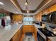 Well-lit kitchen featuring stainless steel appliances, granite counters and wood cabinets at 604 S Xenon Ct, Lakewood, CO 80228