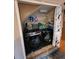 Compact laundry area with a washer and dryer set, storage shelves, and a decorative curtain at 604 S Xenon Ct, Lakewood, CO 80228