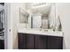 Well-lit bathroom with a modern vanity, a large mirror, and a shower with patterned curtains at 8707 E Florida Ave # 814, Denver, CO 80247