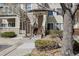 Inviting townhouse entrance with wood stairs and neutral siding complemented by mature trees and landscaping at 8707 E Florida Ave # 814, Denver, CO 80247
