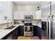 Modern kitchen with stainless steel appliances, white cabinets, stylish backsplash, and granite countertops at 8707 E Florida Ave # 814, Denver, CO 80247