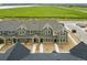 Aerial view of townhomes showcasing green exteriors, open fields, and a scenic view at 17115 W 91St Ln, Arvada, CO 80007