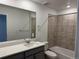 Full bathroom featuring a shower-tub combo with tiled wall, large mirror, and single sink at 17115 W 91St Ln, Arvada, CO 80007