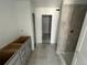 Modern bathroom with gray-tiled shower and unfinished vanity at 17115 W 91St Ln, Arvada, CO 80007