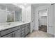Bathroom featuring double vanity, quartz countertop, and glass-enclosed shower at 17115 W 91St Ln, Arvada, CO 80007