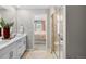 Bathroom features a double vanity, glass shower, and view into the primary bedroom at 17115 W 91St Ln, Arvada, CO 80007