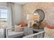 Bright bedroom with two cribs, natural light, and decorative wallpaper at 17115 W 91St Ln, Arvada, CO 80007