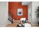 Charming entryway with modern chair, stairway and decor against orange accent wall, wood laminate flooring at 17115 W 91St Ln, Arvada, CO 80007