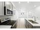 Bright open kitchen includes stainless appliances, gray cabinets and an island with sink at 17115 W 91St Ln, Arvada, CO 80007