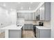 Bright kitchen with gray cabinets, stainless appliances, modern countertops and an island at 17115 W 91St Ln, Arvada, CO 80007