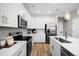 Modern kitchen featuring white cabinets, stainless steel appliances, and a stylish backsplash at 17115 W 91St Ln, Arvada, CO 80007