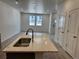Open kitchen and living area featuring an island with a stainless steel sink and light wood floors at 17115 W 91St Ln, Arvada, CO 80007