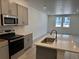 Well-lit kitchen featuring stainless steel appliances, light wood floors and gray cabinets at 17115 W 91St Ln, Arvada, CO 80007