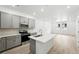 Bright open kitchen includes stainless appliances, gray cabinets and an island with sink at 17115 W 91St Ln, Arvada, CO 80007