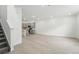 Open-concept living space with gray wood floors leading to a modern kitchen and staircase at 17115 W 91St Ln, Arvada, CO 80007