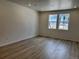 Bright open living area featuring light wood floors and two windows facing the front yard at 17115 W 91St Ln, Arvada, CO 80007