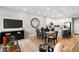 Bright and open living room with modern lighting, dining table, stainless steel appliances, and white cabinets at 17115 W 91St Ln, Arvada, CO 80007