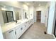 Spacious bathroom featuring dual sinks, white cabinetry, and a walk-in shower at 3443 N Denali St, Aurora, CO 80019
