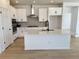 Modern kitchen with white cabinets, stainless steel appliances, and a large center island at 3443 N Denali St, Aurora, CO 80019