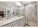 Bathroom with double sink vanity, granite countertop, and a glass-enclosed shower at 17409 Springfield Dr, Parker, CO 80134