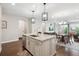 Modern kitchen island with stainless steel appliances, pendant lights, and an open view to the dining area at 17409 Springfield Dr, Parker, CO 80134