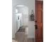 Hallway with hardwood floors leading to a kitchen with white cabinetry and appliances at 215 E 11Th Ave # A5, Denver, CO 80203