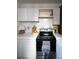 Cozy kitchen featuring white cabinets, tiled countertops and backsplash, and a black stove at 215 E 11Th Ave # A5, Denver, CO 80203