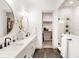 Bright bathroom featuring double sinks, walk-in shower, and a walk-in closet for storage at 1925 W 165Th Way, Broomfield, CO 80023