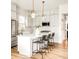 Bright kitchen features white cabinets, stainless appliances, a kitchen island with bar stool seating and modern pendant lights at 1925 W 165Th Way, Broomfield, CO 80023