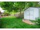 Spacious backyard featuring a storage shed, pergola with seating, bench swing, and lush landscaping at 3125 Xenon St, Wheat Ridge, CO 80215