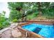 Relaxing backyard with chairs around a fire pit, hot tub, and treehouse in the background at 3125 Xenon St, Wheat Ridge, CO 80215