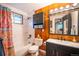 Cozy bathroom features a shower-tub combo, wood accent wall and stylish fixtures at 3125 Xenon St, Wheat Ridge, CO 80215