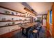 Dining room with brick accent wall, filled with plants, and a modern light fixture over a long table at 3125 Xenon St, Wheat Ridge, CO 80215