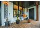 Cozy front porch featuring wood flooring, charming decor, a black door, and white painted brick at 3125 Xenon St, Wheat Ridge, CO 80215