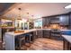 Stylish kitchen featuring a large island, dark wood cabinets, quartz countertops, and modern appliances at 3125 Xenon St, Wheat Ridge, CO 80215
