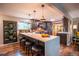 Modern kitchen with an island, quartz countertops, dark wood cabinets, and stainless steel appliances at 3125 Xenon St, Wheat Ridge, CO 80215