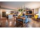 Open-concept living space with hardwood floors, a brick fireplace, and a kitchen island with bar seating at 3125 Xenon St, Wheat Ridge, CO 80215