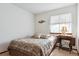 Cozy bedroom with a comfortable bed, decorative accents, and a window dressed with sheer curtains at 98 N Quicksilver Ave, Castle Rock, CO 80104