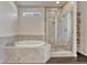 Beautiful bathroom featuring a soaking tub and glass enclosed shower with tiled walls and recessed shelving at 2153 Abigail Ln, Castle Rock, CO 80104