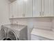 Laundry room featuring white cabinets, a counter top, and modern washer and dryer at 2153 Abigail Ln, Castle Rock, CO 80104
