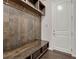 Mudroom with a wooden bench, hooks and shelves for storage near a white door at 2153 Abigail Ln, Castle Rock, CO 80104