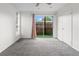 Bright bedroom features sliding glass door with view of yard, neutral walls, and gray carpet at 865 S Quebec St # 101B, Denver, CO 80247