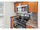 Modern kitchen appliance suite featuring oven, microwave, and smooth cooktop at 865 S Quebec St # 101B, Denver, CO 80247