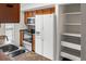 This kitchen is equipped with stainless steel appliances, wooden cabinets, and open shelving at 865 S Quebec St # 101B, Denver, CO 80247