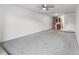 Open living room features neutral walls, gray carpet, and a view of the kitchen at 865 S Quebec St # 101B, Denver, CO 80247