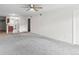 Open concept living room features gray carpet and a view of the kitchen and front entrance at 865 S Quebec St # 101B, Denver, CO 80247