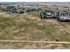 Wide aerial shot of a property featuring large grassy area and surrounding homes at 3550 E 160Th Ave, Thornton, CO 80602